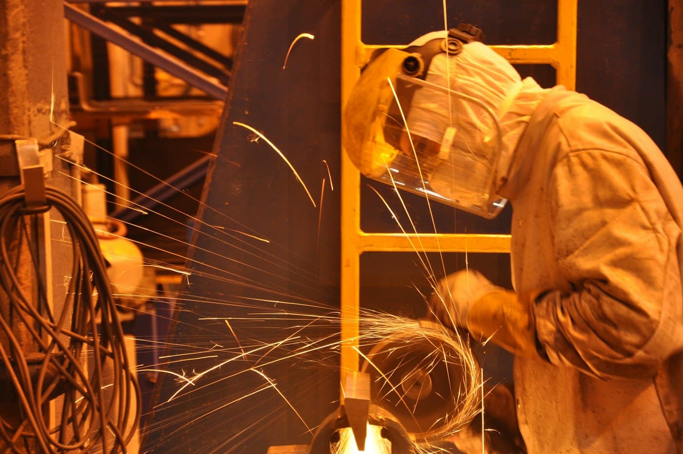 Worker in protective clothing amid sparks