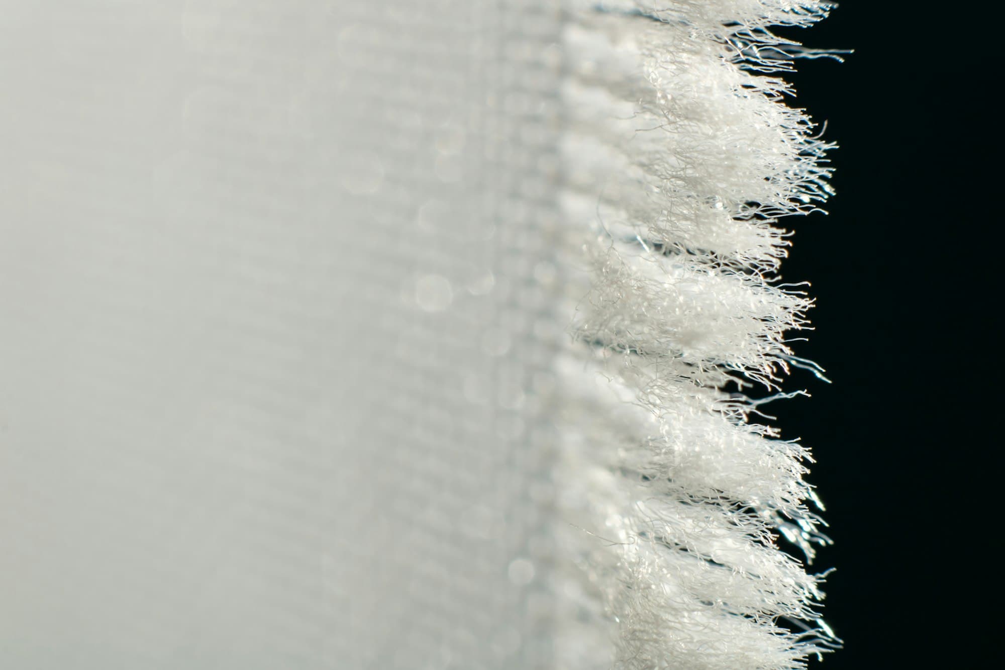 Frayed edge of a white glass-fibre cloth